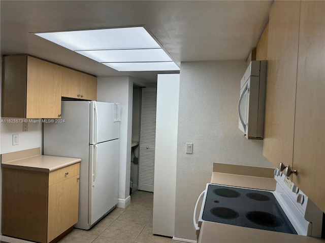 kitchen with white appliances and light tile patterned floors