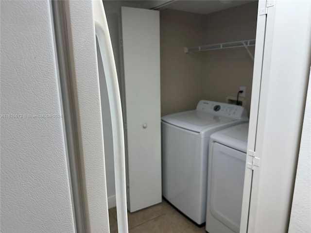 washroom with light tile patterned flooring and washing machine and dryer