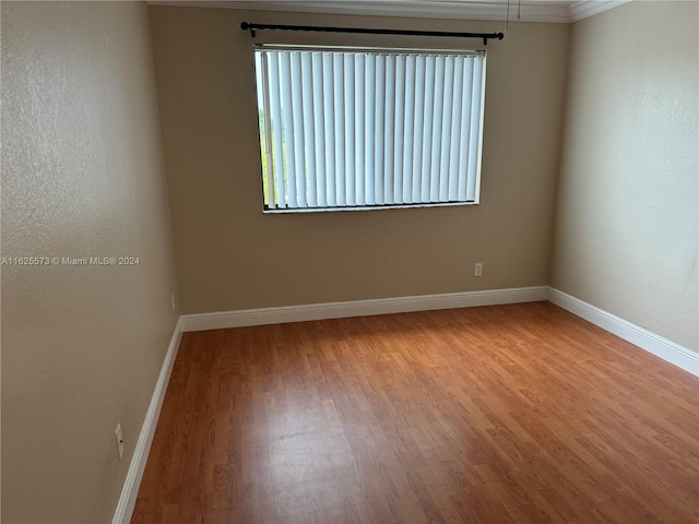 unfurnished room with crown molding and light hardwood / wood-style flooring