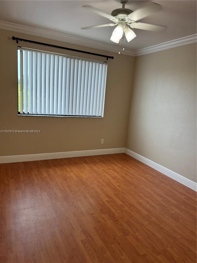 empty room with ornamental molding, light wood-type flooring, and ceiling fan