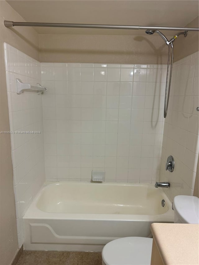 full bathroom featuring tiled shower / bath, vanity, and toilet