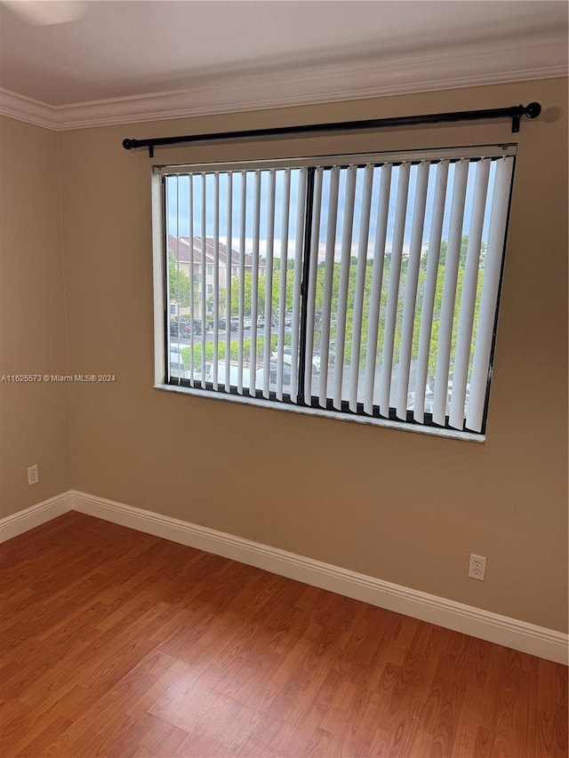 empty room with crown molding and hardwood / wood-style floors