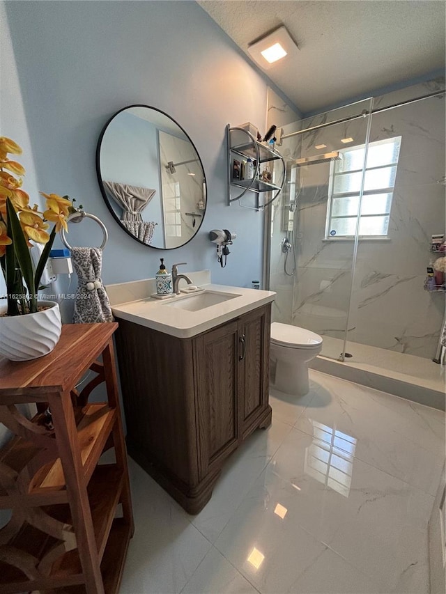 bathroom featuring vanity, a shower with door, toilet, and a textured ceiling