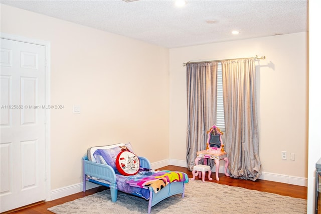 bedroom with wood-type flooring and a textured ceiling