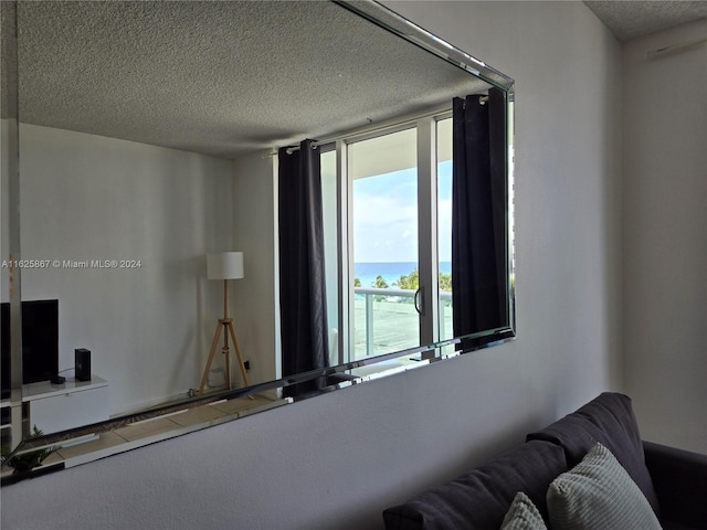 interior space with a textured ceiling and a water view