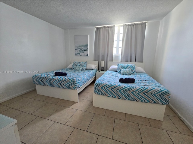 bedroom featuring a textured ceiling and light tile patterned floors