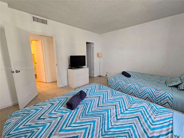 bedroom featuring a textured ceiling and light tile patterned floors