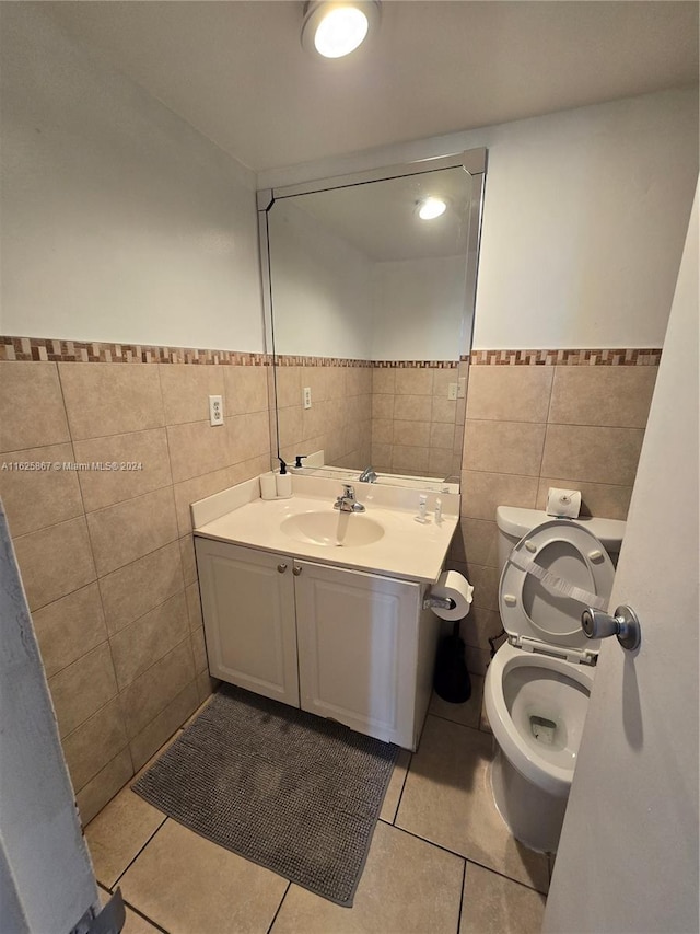 bathroom featuring toilet, tile walls, vanity, and tile patterned floors