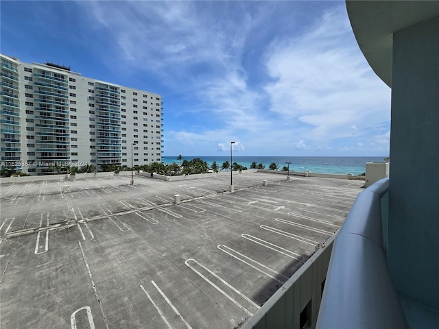 view of car parking featuring a water view