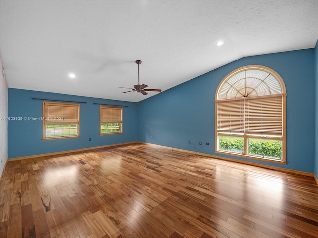 unfurnished room with hardwood / wood-style flooring, lofted ceiling, a textured ceiling, and ceiling fan