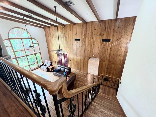 stairway with beamed ceiling and hardwood / wood-style flooring