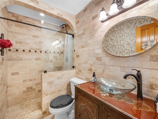 bathroom featuring vanity, tasteful backsplash, tile walls, a shower with curtain, and toilet