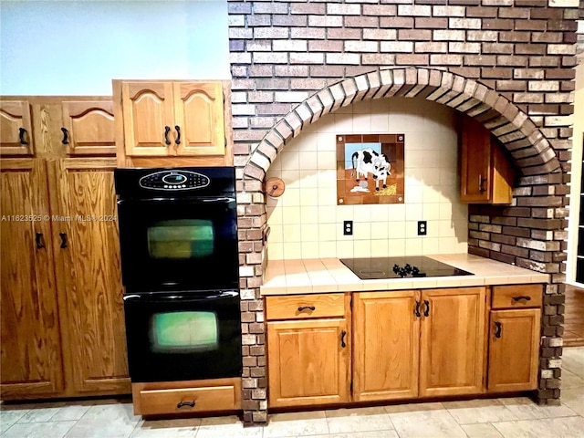 kitchen with tasteful backsplash, tile countertops, and black appliances