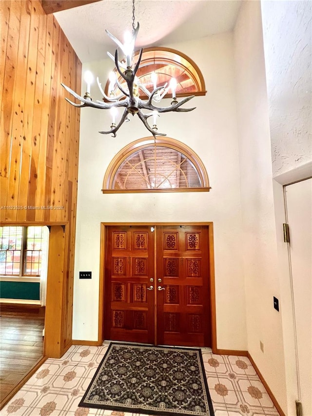 foyer with high vaulted ceiling and a chandelier