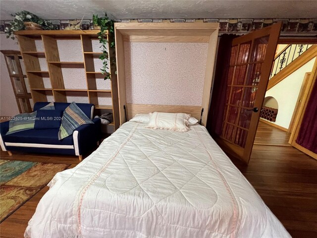 bedroom featuring hardwood / wood-style flooring and a textured ceiling