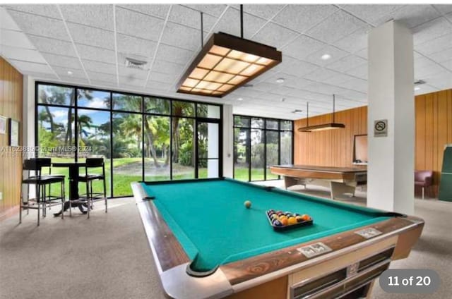 recreation room featuring wooden walls, a wall of windows, carpet floors, and billiards