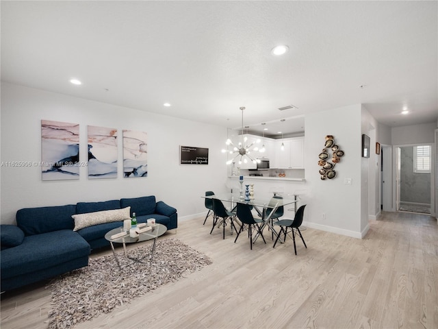 living room featuring light wood-type flooring and a chandelier