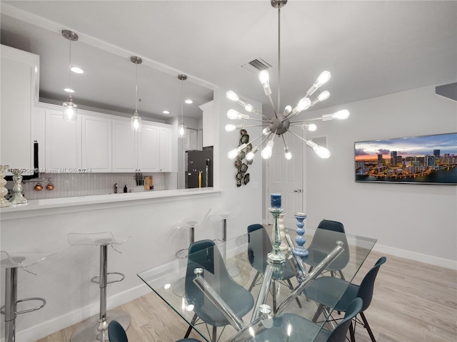 dining space featuring a chandelier and light wood-type flooring