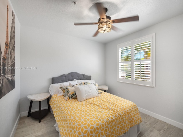 bedroom featuring a textured ceiling, light hardwood / wood-style flooring, and ceiling fan