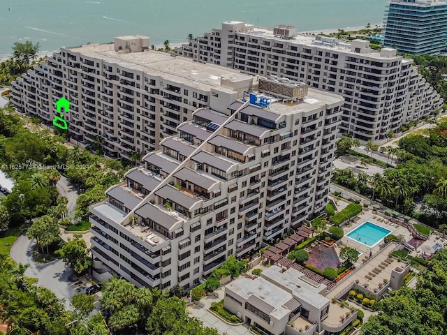 view of building exterior with a water view and a community pool