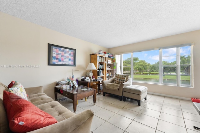 tiled living room with a water view and a textured ceiling