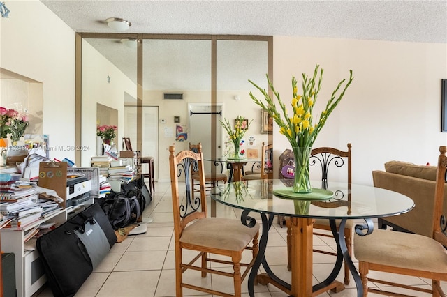 tiled dining room featuring a textured ceiling