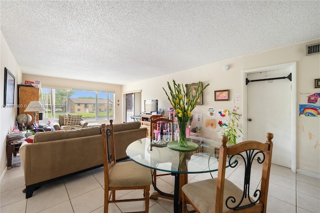 dining room featuring a textured ceiling and light tile patterned floors