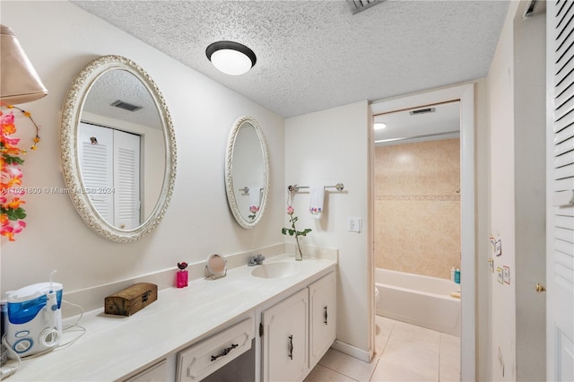 bathroom with tile patterned flooring, bathing tub / shower combination, vanity, and a textured ceiling