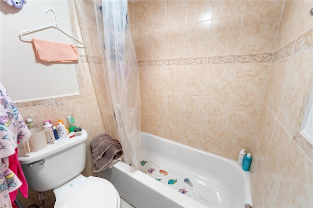 bathroom with tile walls, toilet, and shower / tub combo with curtain