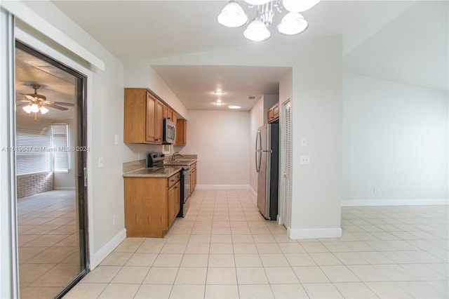 kitchen featuring vaulted ceiling, ceiling fan, appliances with stainless steel finishes, and light tile patterned floors