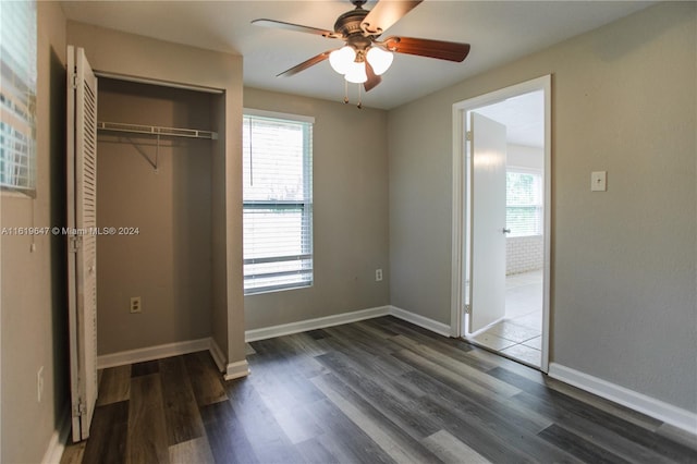 unfurnished bedroom with ceiling fan, dark hardwood / wood-style floors, and a closet