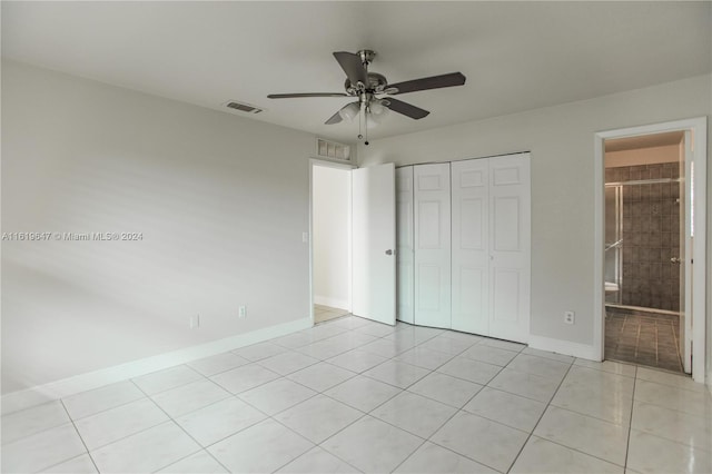 unfurnished bedroom with ceiling fan, connected bathroom, a closet, and light tile patterned flooring