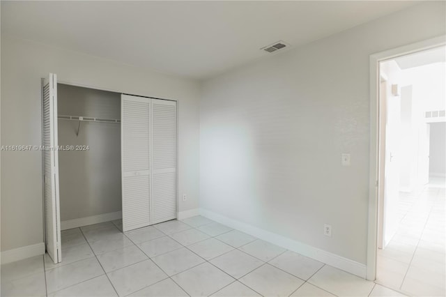 unfurnished bedroom with light tile patterned floors and a closet