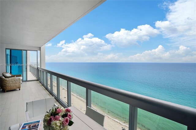 balcony featuring a water view and a view of the beach