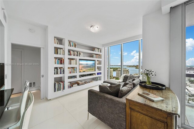 tiled living room featuring built in shelves and floor to ceiling windows