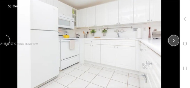 kitchen with white cabinetry, light tile patterned flooring, white appliances, sink, and backsplash