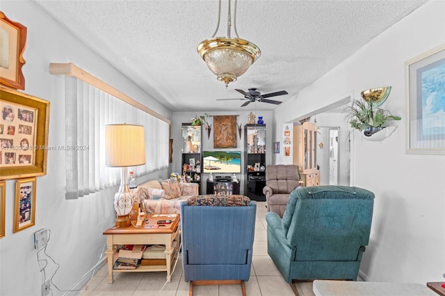 living room with light tile patterned flooring, a textured ceiling, and ceiling fan