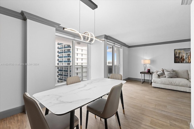 dining area featuring crown molding and light wood-type flooring