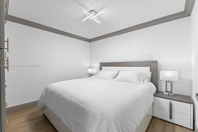 bedroom with crown molding and dark hardwood / wood-style floors