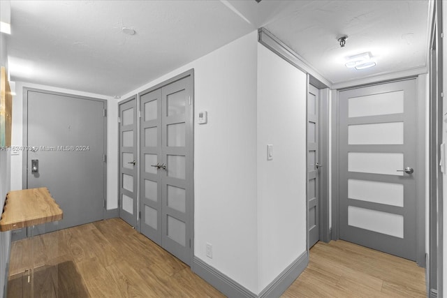 foyer entrance featuring light hardwood / wood-style flooring and ornamental molding