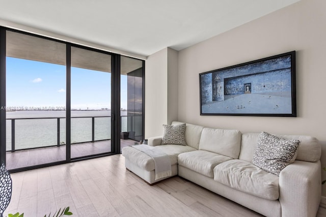 480 NE 31st St Unit 1005, Miami, FL 33137 - living area with a wall of windows, light wood-style flooring, and a water view