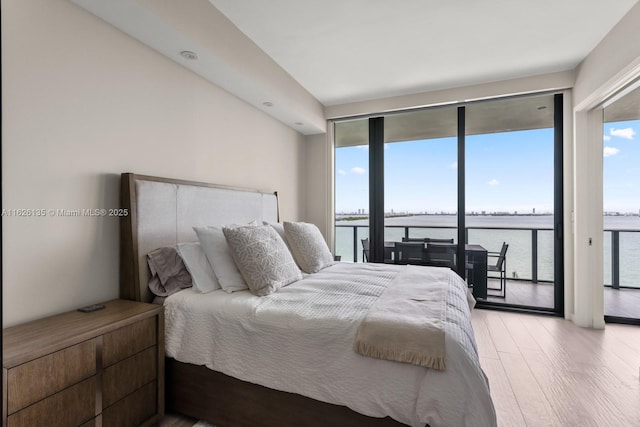 480 NE 31st St Unit 1005, Miami, FL 33137 - bedroom featuring access to exterior, a water view, and wood finished floors