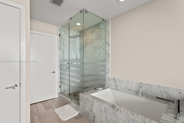 480 NE 31st St Unit 1005, Miami, FL 33137 - full bathroom featuring a garden tub, a stall shower, wood finished floors, and recessed lighting