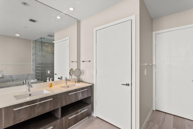 480 NE 31st St Unit 1005, Miami, FL 33137 - full bathroom with a shower stall, double vanity, wood finished floors, and recessed lighting