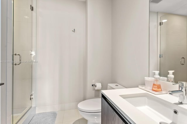 bathroom featuring a shower with shower door, toilet, tile patterned flooring, and vanity