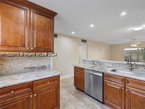 kitchen with tasteful backsplash, sink, light stone countertops, and dishwasher