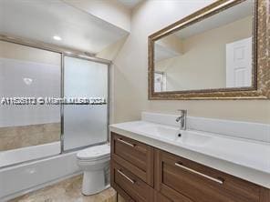 full bathroom with vanity, toilet, and combined bath / shower with glass door