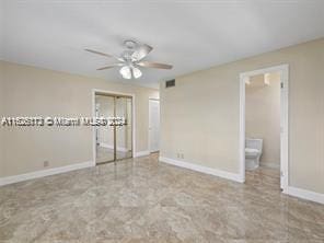 unfurnished bedroom with connected bathroom and ceiling fan