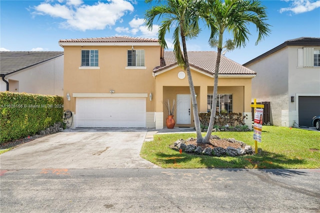 mediterranean / spanish home featuring a garage and a front yard