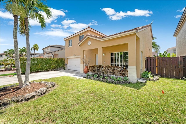 mediterranean / spanish-style home featuring fence, a front yard, stucco siding, concrete driveway, and an attached garage